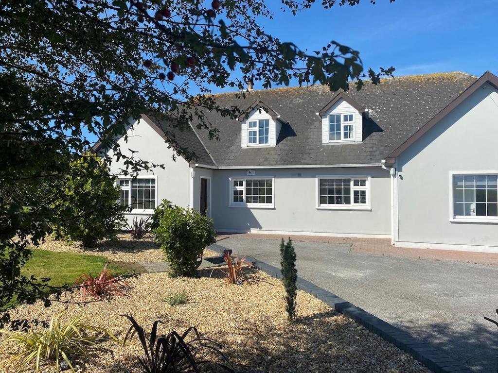 a white house with a black roof at Daline House Clonakilty in Clonakilty