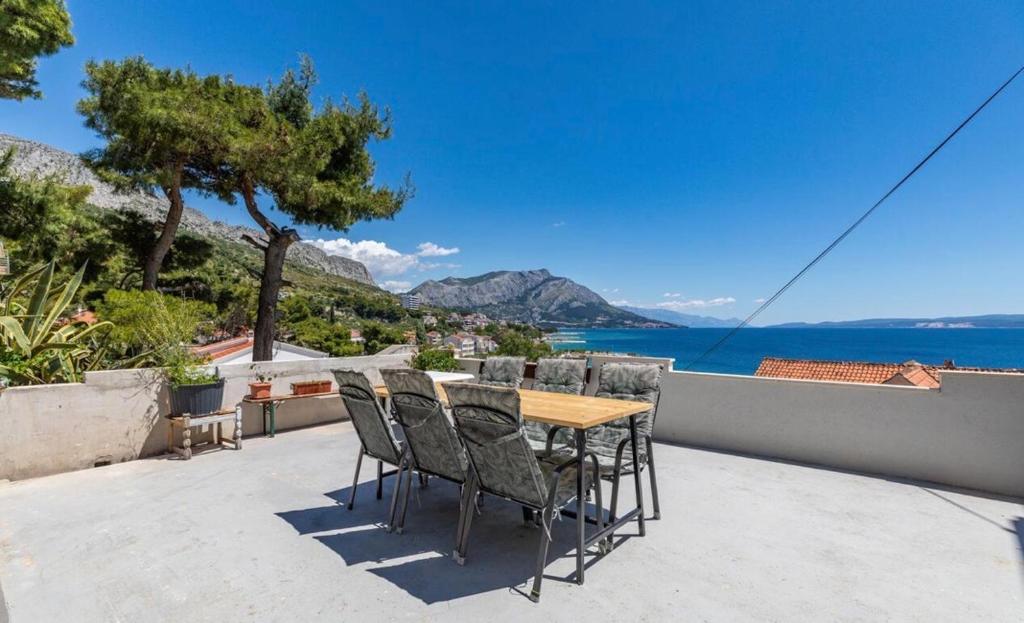 a table and chairs on a balcony with a view of the water at Miljak in Duće