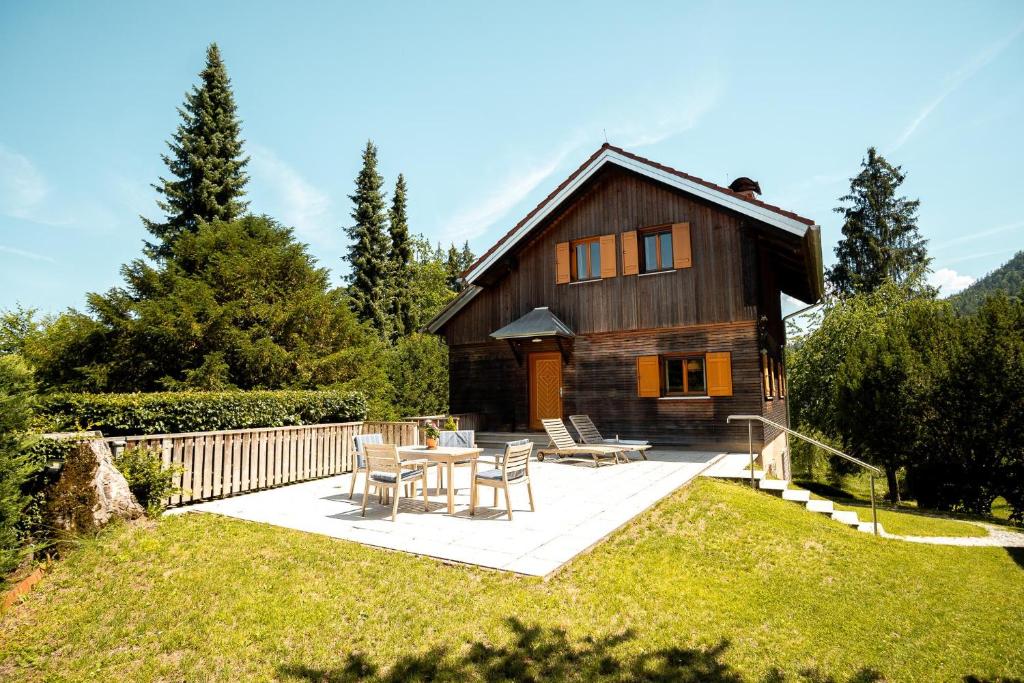 a wooden house with a table and chairs in the yard at Haus Uschi in Klagenfurt