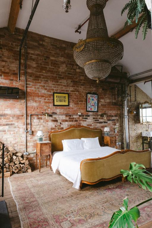 a bedroom with a large bed in a brick wall at Jason Works in Loughborough