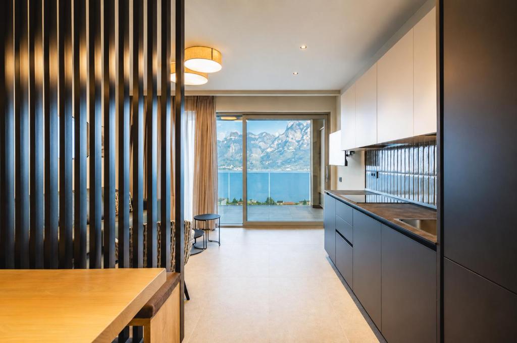 a kitchen with a view of the ocean and mountains at Eos Lake House Luxury in Limone sul Garda