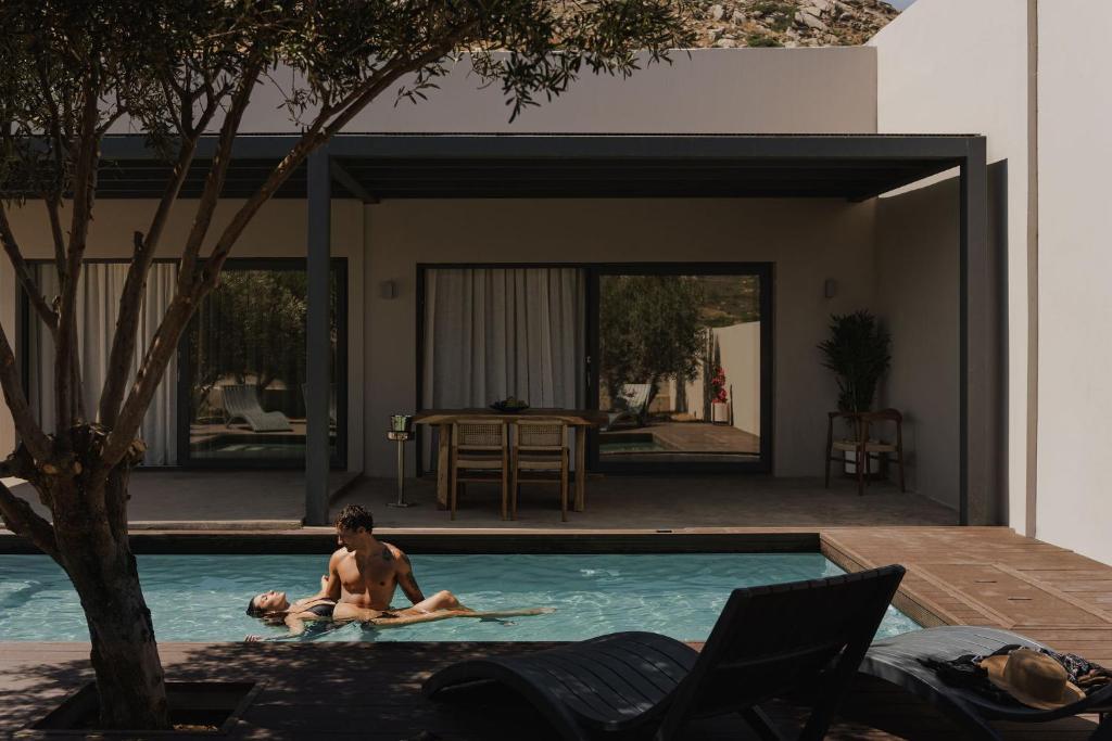 Ein Mann in einem Swimmingpool neben einem Haus in der Unterkunft Mitos Ultimate Escape Villa in Galanádhon