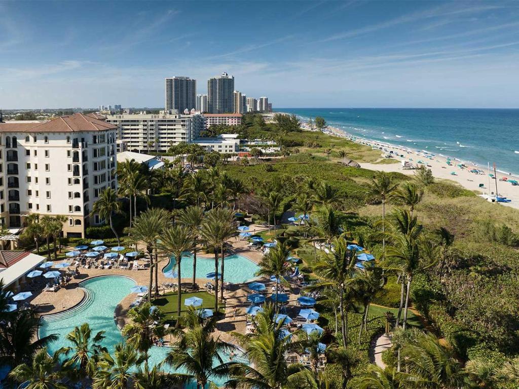 an aerial view of a resort with a pool and a beach at Ocean Pointe Resort Two-Bedroom Villa in Palm Beach Shores