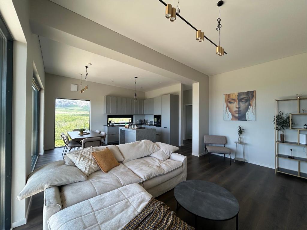 a living room with a white couch and a table at Brúarárbyggð A2 in Blaskogabyggo