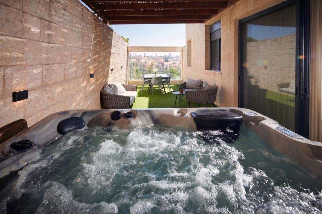 a dog in a hot tub in a house at GABRIEL APARTMENTS - Jacuzzi & Panoramic JLM View Steps to Shaare Zedek Hospital in Bayit Wegan