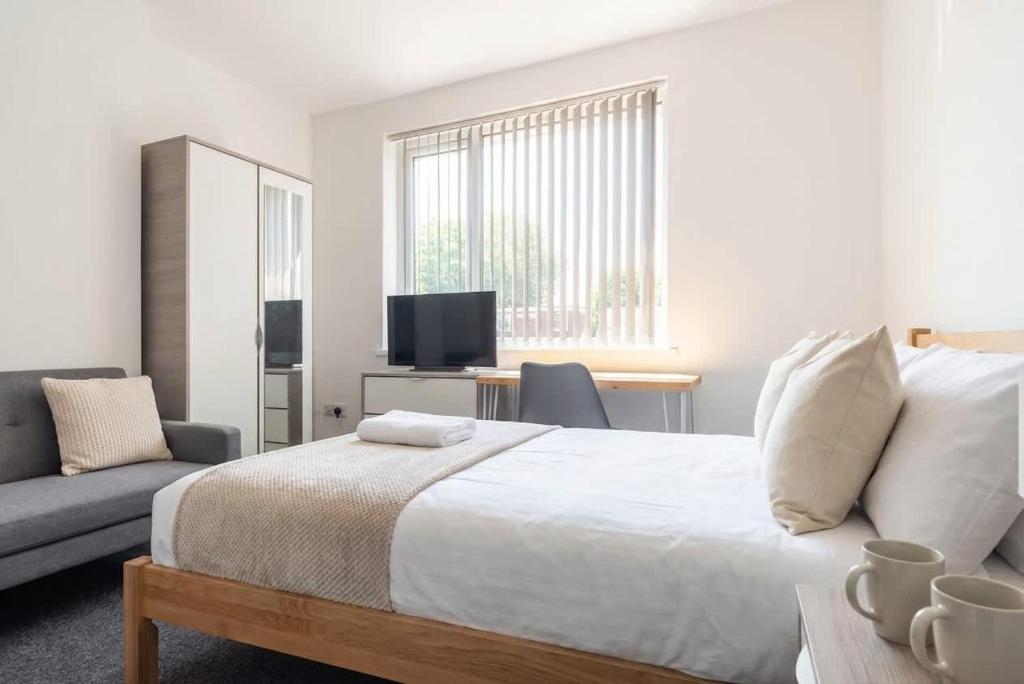 a bedroom with a bed and a couch and a television at Doncaster Budget Room in Shared House w Kitchen in Doncaster