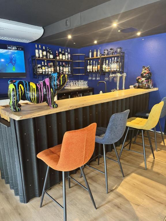 a bar with colorful chairs and a counter in a restaurant at Hotel Restaurant Kyriad Brive Centre in Brive-la-Gaillarde