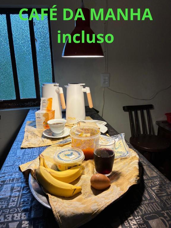 a table with bananas and other food on it at Hostel REIBIER in Blumenau
