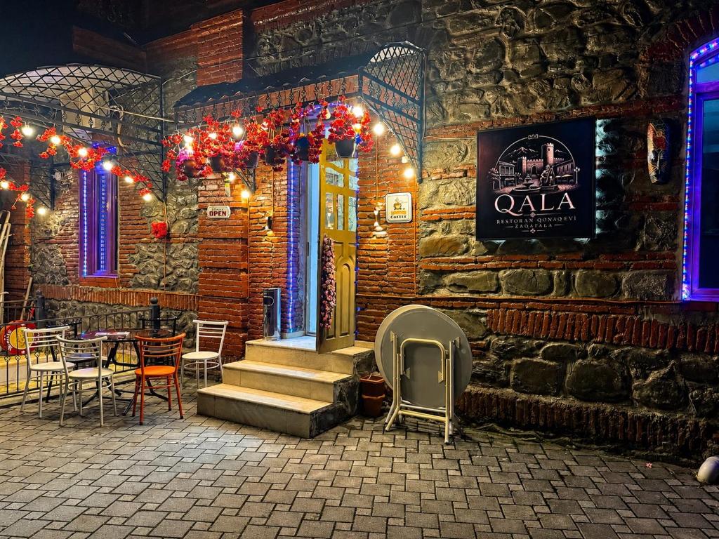 a restaurant with a table and chairs and lights at Mountain-city in Zaqatala