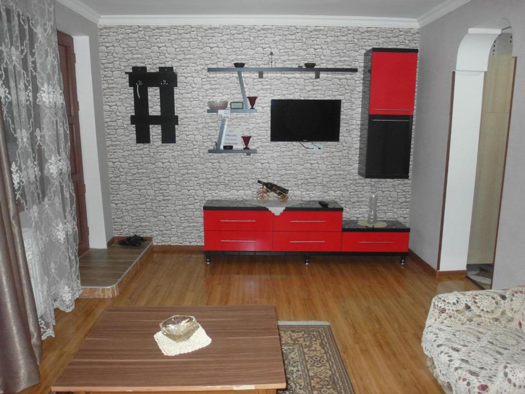 a living room with a red cabinet and a tv at Villa Lazika in Borjomi