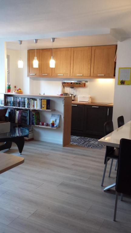 a large kitchen with wooden cabinets and a table at Aligre in Paris