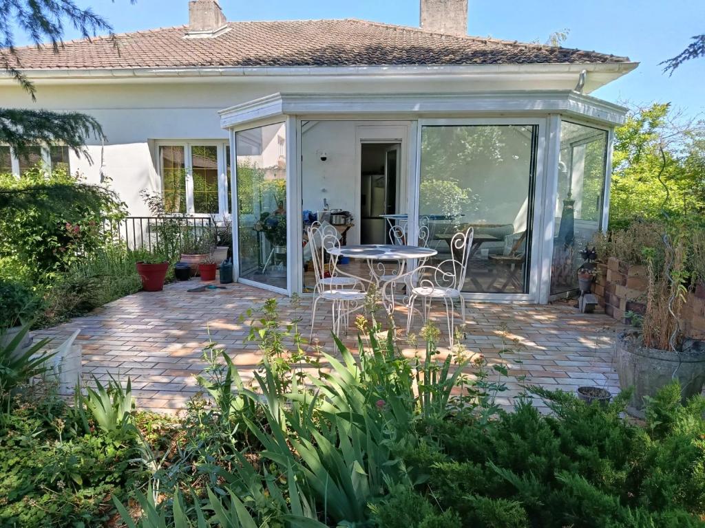 a patio with a table and chairs in front of a house at Très belle chambre à Metz in Metz