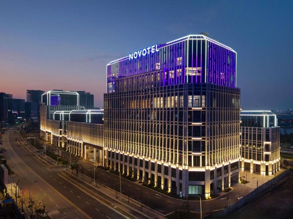 a tall building with a sign on the side of it at Novotel Shanghai Lingang in Zhenghai