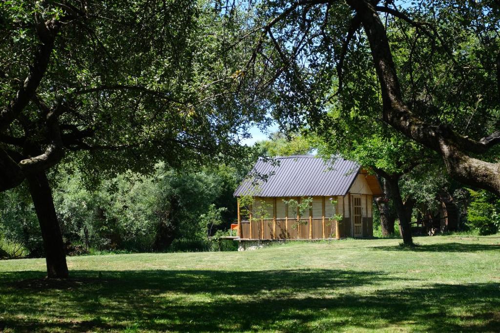 a cabin in the middle of a field with trees at Riverside Apartment in Nikšić