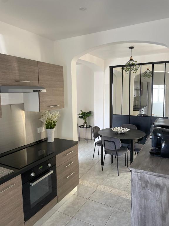 a kitchen and dining room with a table and chairs at Appart dans bâtisse provençale in Sorgues