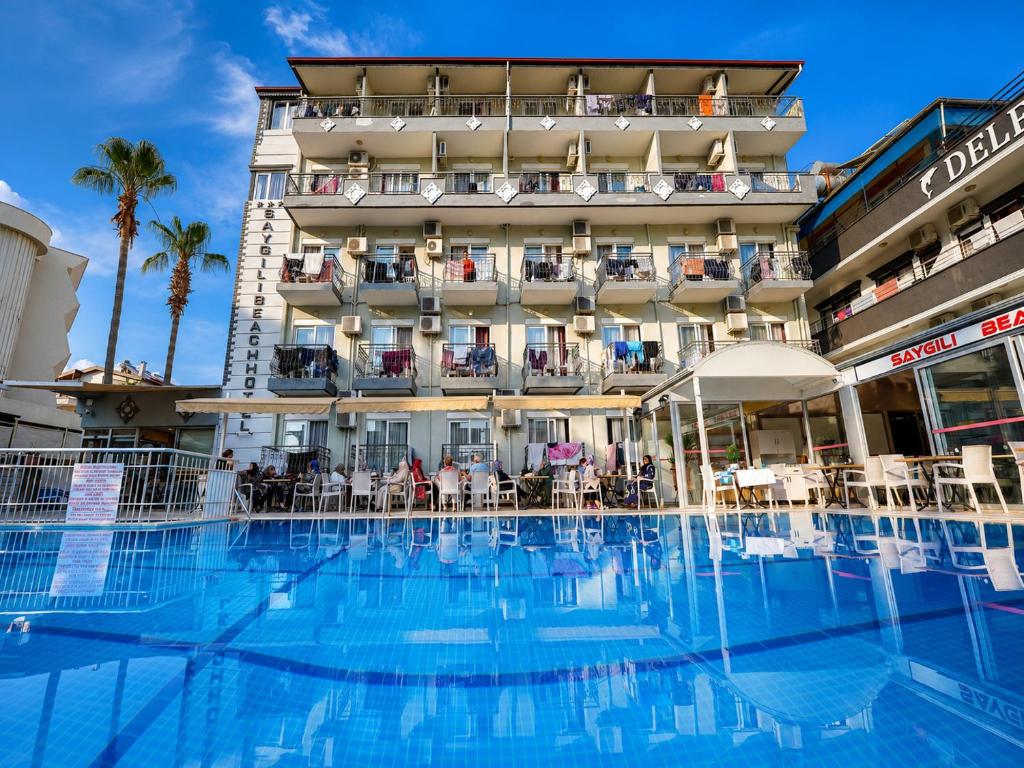 ein Hotel mit einem großen Swimmingpool vor einem Gebäude in der Unterkunft Saygili beach hotel in Side