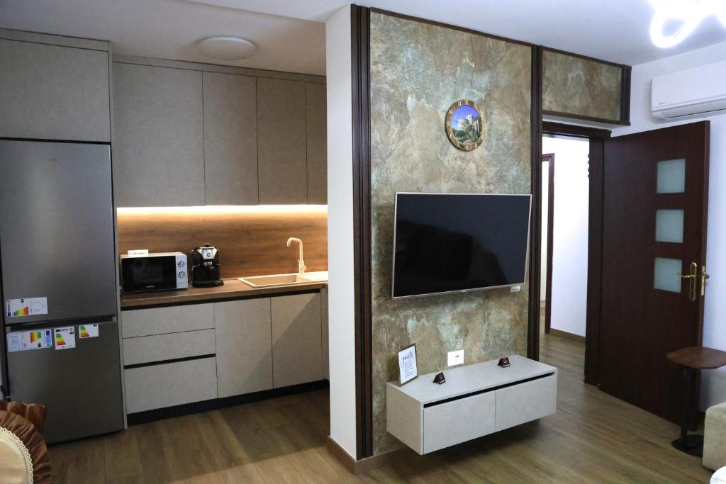 a kitchen with a tv on the wall and a table at Joni s Guest House in Krujë