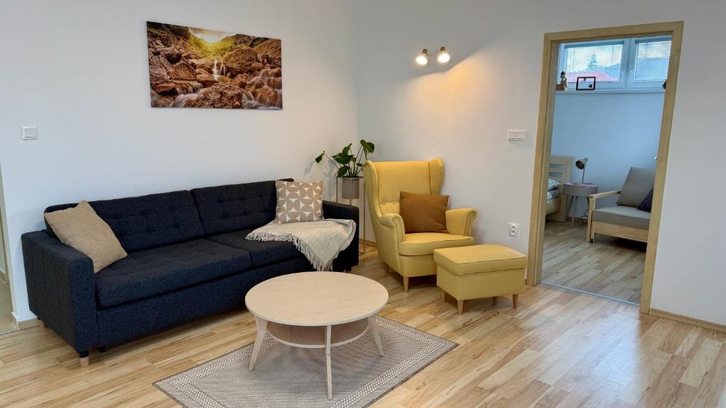 a living room with a couch and a table and chairs at Šturka Apartment in Martin