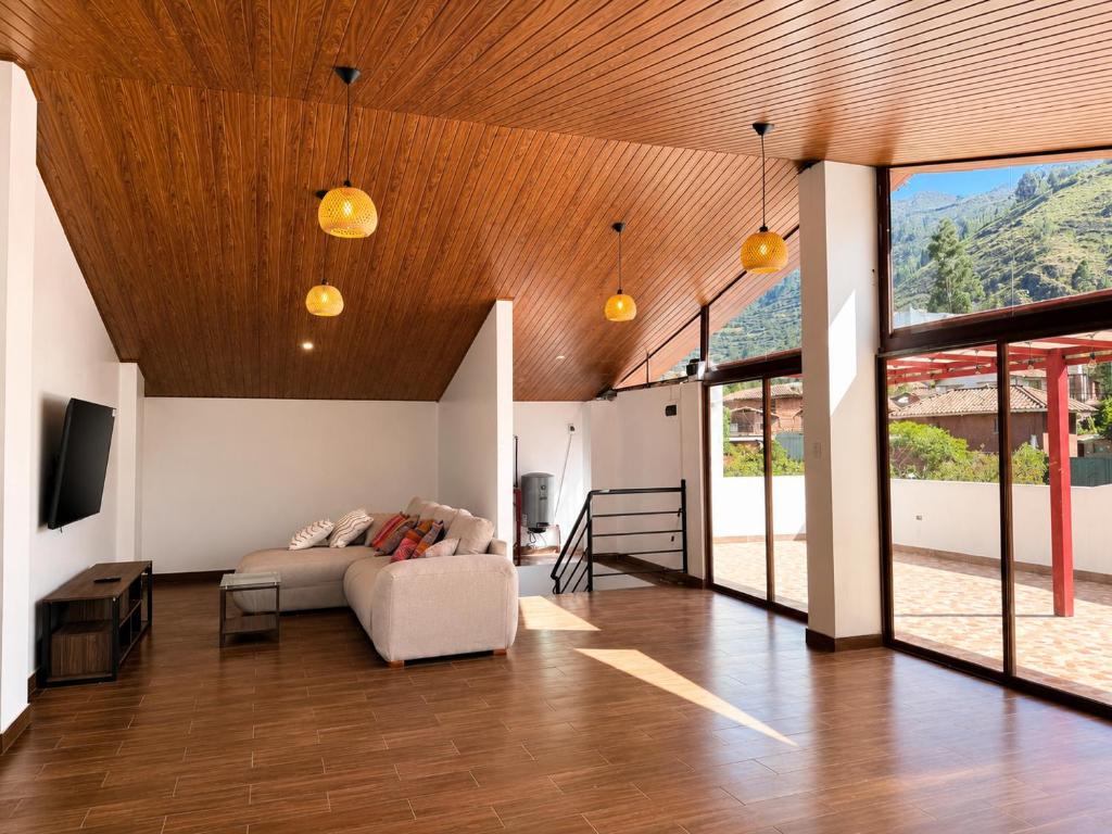 a living room with a couch and some windows at Qantu casa Boutique in Calca