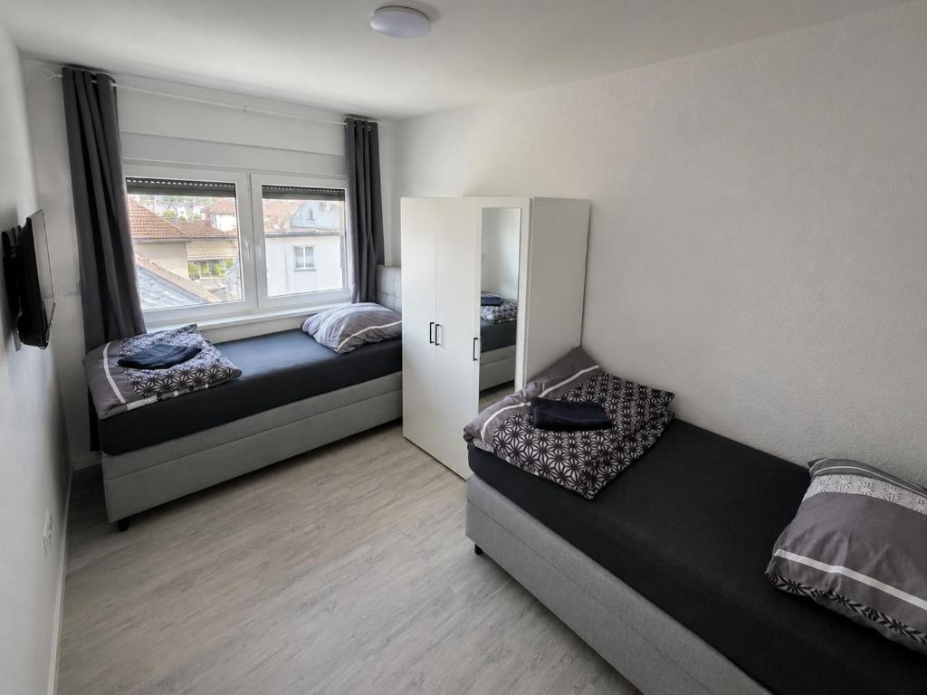 a bedroom with two beds and a window at Worms City Suites Löwengasse in Worms