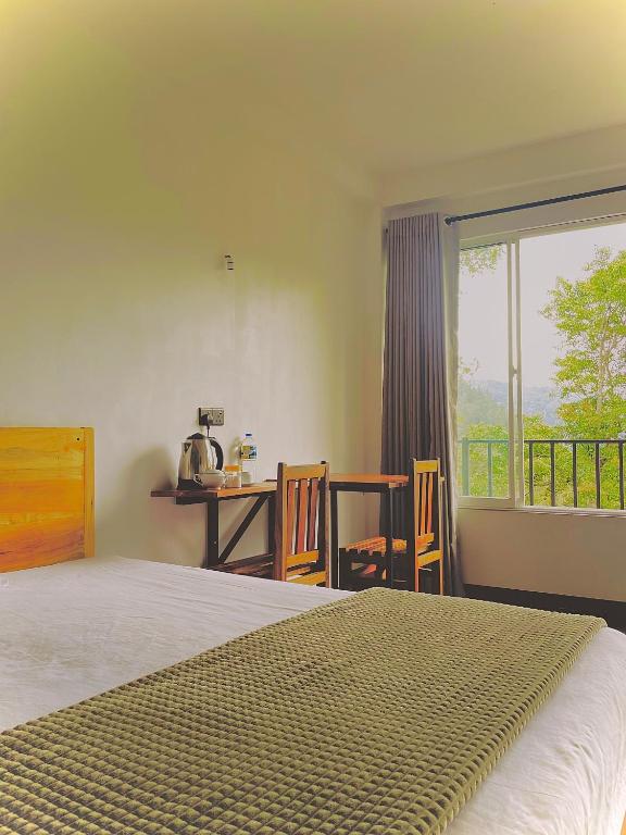 ein Schlafzimmer mit einem Bett, einem Tisch und einem Fenster in der Unterkunft Crystal Resort in Badulla