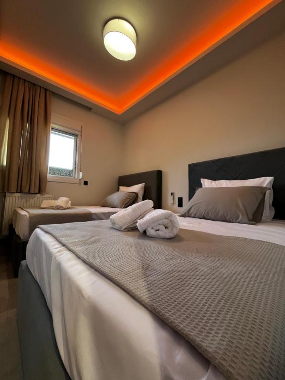 two beds in a bedroom with an orange ceiling at Thomas Luxury home in Plisioí