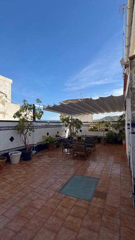 a patio with benches and a canopy on a building at Casa Rural Tío Cuchi in Bolbaite