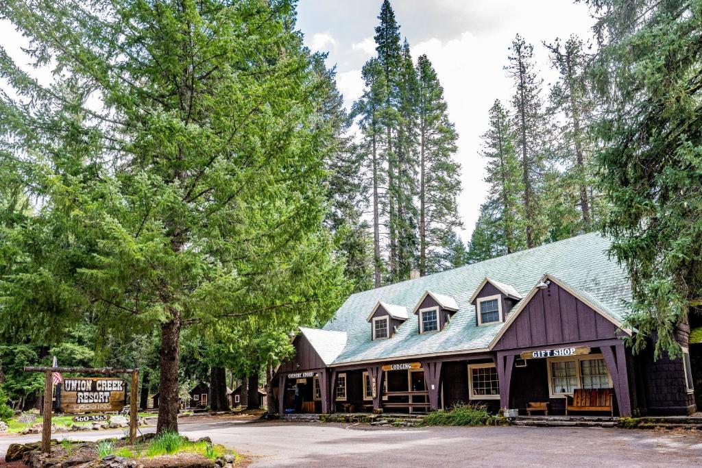 a house in the middle of a forest with trees at Union Creek Resort in Union Creek