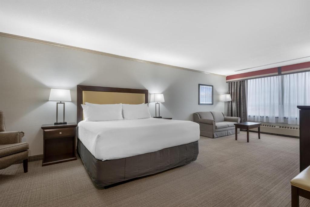 a large hotel room with a bed and a chair at Best Western PLUS Port O'Call Hotel in Calgary