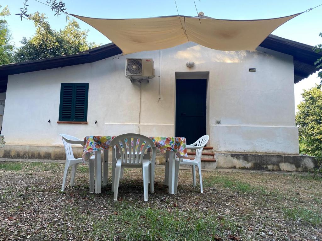 two chairs and a table in front of a house at Medlar apartments in Zambrone