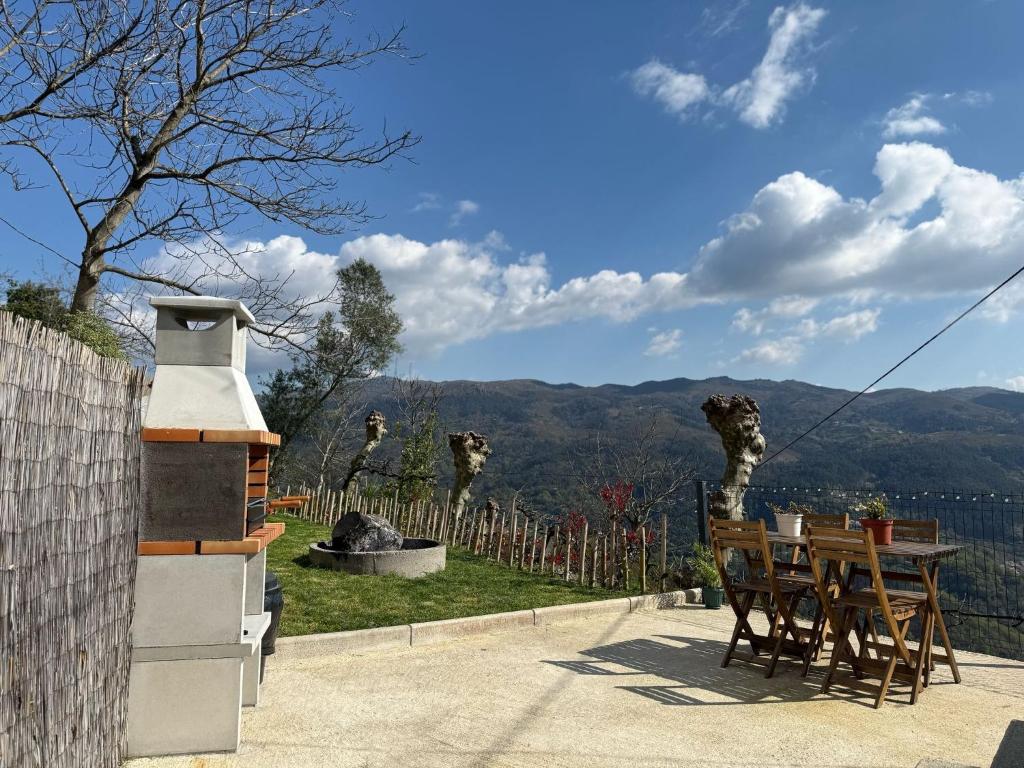 a table and chairs with a view of the mountains at Refúgio da Mariana - Gerês in Terras de Bouro