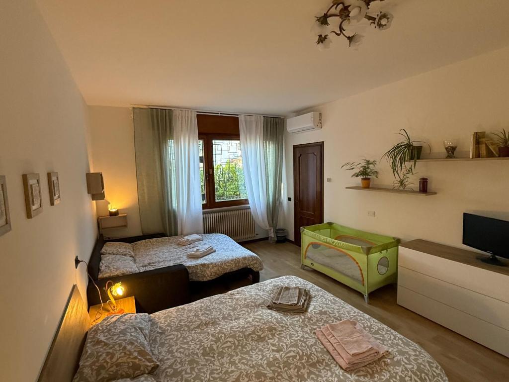 a small room with two beds and a television at Residence Ai Melograni in Silea