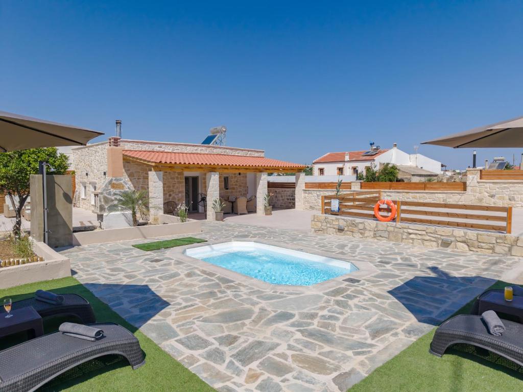 a backyard with a swimming pool and a house at Olea holiday house in Astérion
