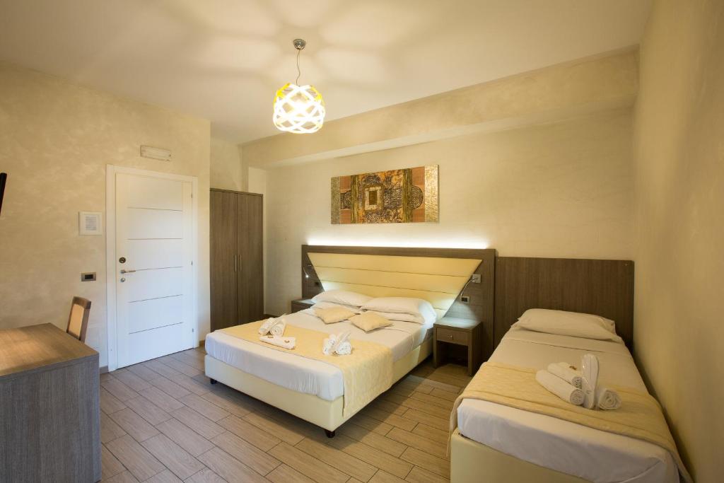 a bedroom with two beds and a chandelier at Relais Tiburtina in Rome