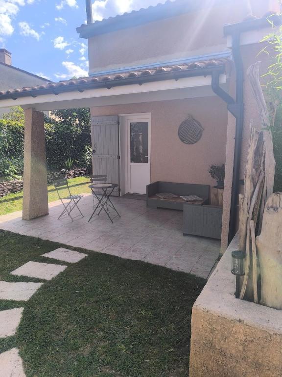 a patio with a couch and a table at Le Cocon des Acacias in Tournon-sur-Rhône