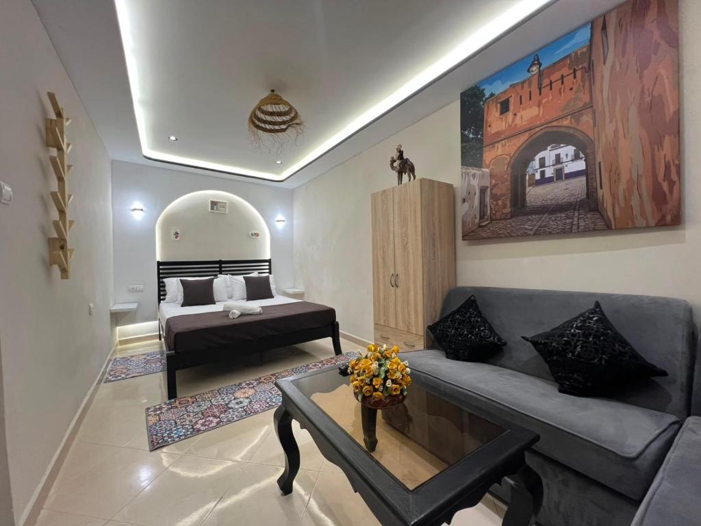 a living room with a couch and a bed at Bab Rmouz apartment in Tétouan