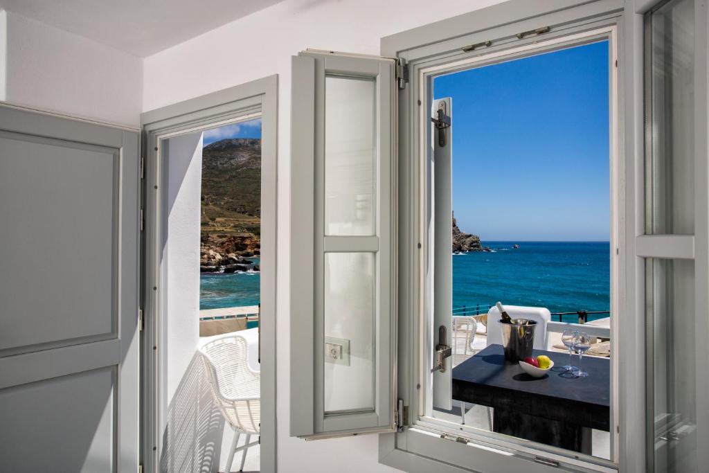 a room with a view of the ocean from a balcony at Blue Sand Boutique Hotel & Suites in Agali