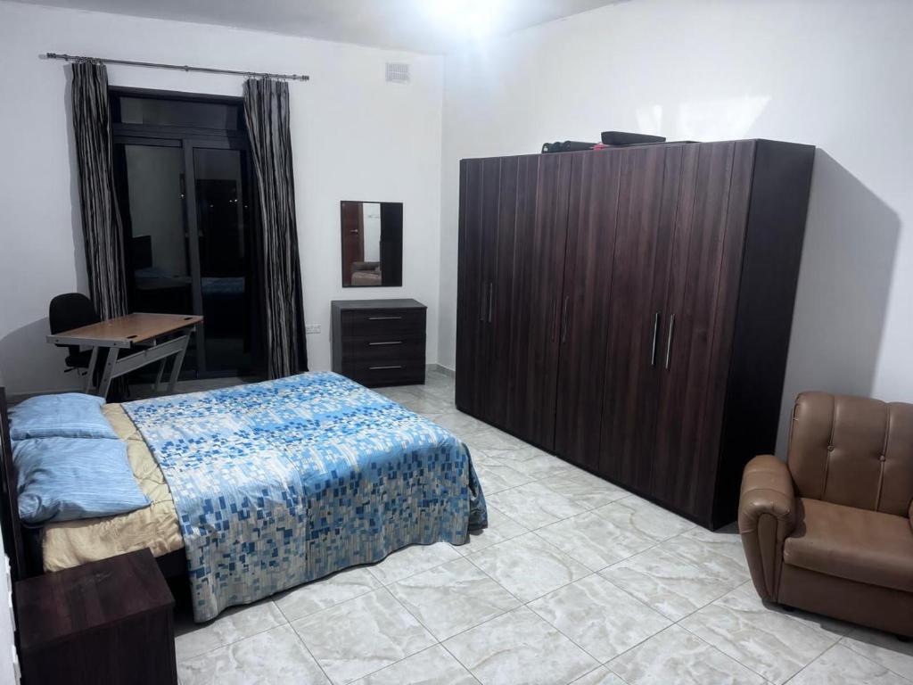 a bedroom with a bed and a cabinet and a desk at Quiet and Lovely Residence in St. Julianʼs