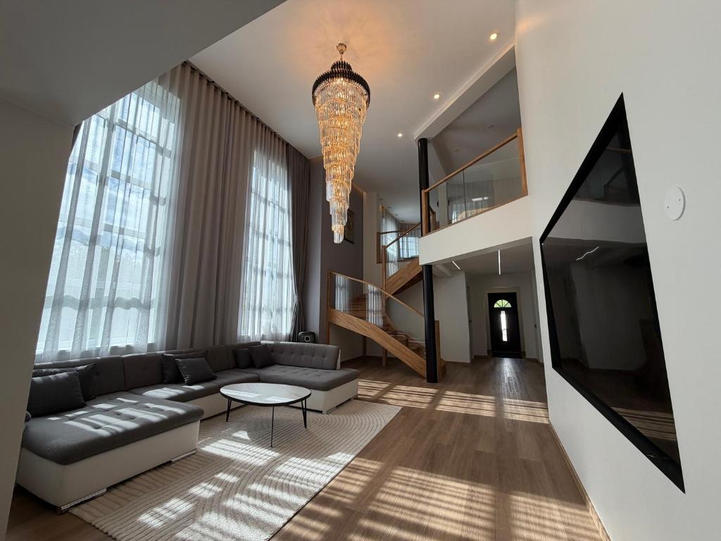 a living room with a couch and a chandelier at Lumy Housing in Pärnu