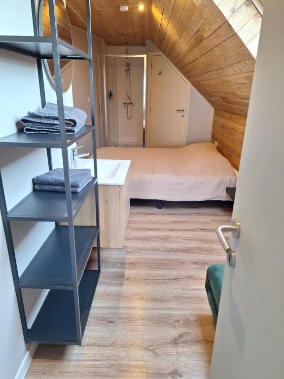 a small room with a bed and a bathroom at Heuvelzicht in Wortegem
