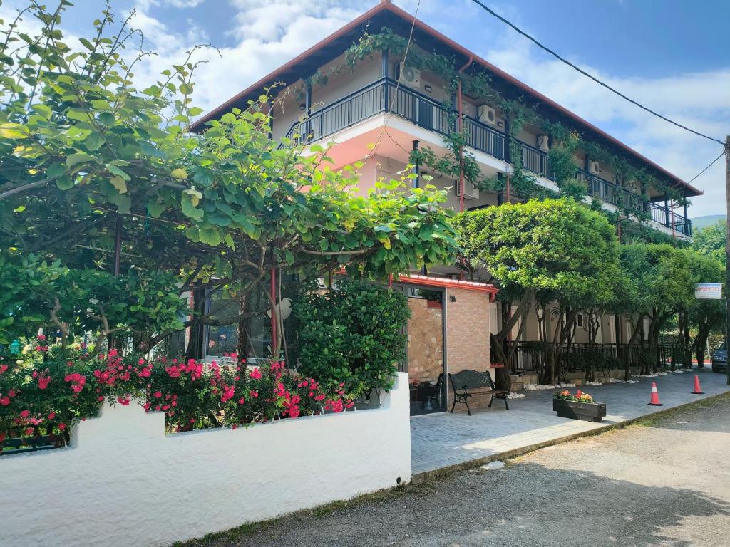 a building with flowers and plants in front of it at Helena Apartments in Paralia Panteleimonos