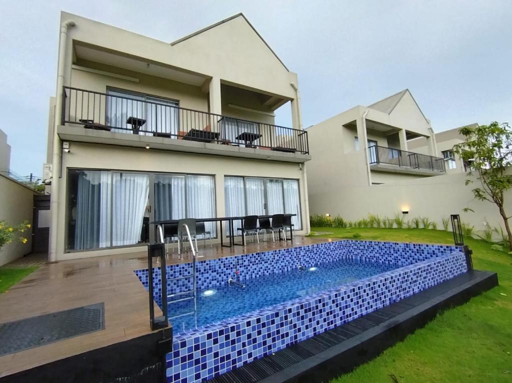 a house with a swimming pool in front of a house at Villa 80 in Gonapola