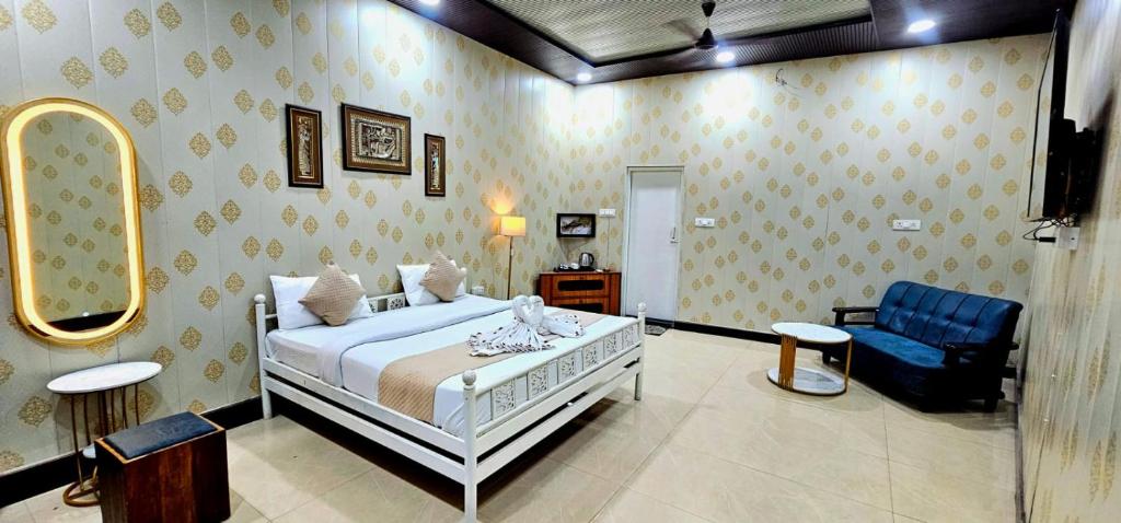 a bedroom with a bed and a blue chair at Hotel raj inn in Lucknow