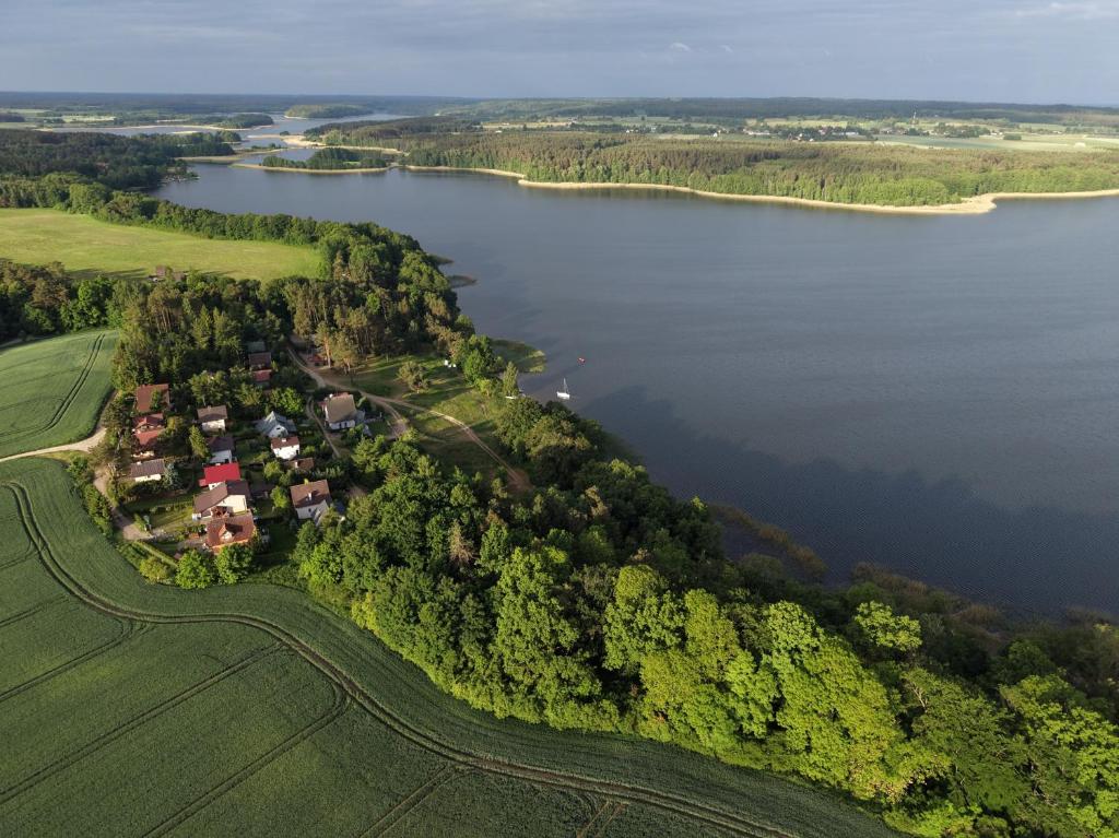 an aerial view of a house on the shore of a lake at wschód nad polaną 17 in Dobrzyń