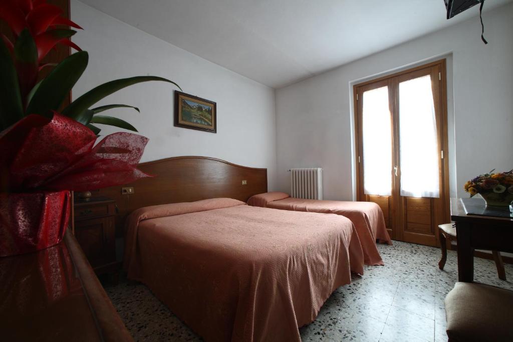 Habitación de hotel con 2 camas y ventana en Albergo Ristorante il Poggiolo, en San Marcello Pistoiese