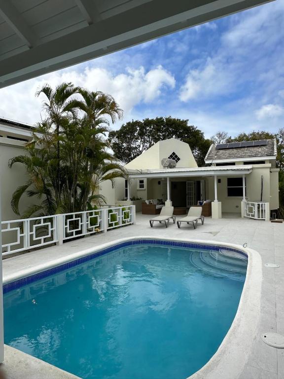 a swimming pool in front of a house at Casa Colibri in Saint James
