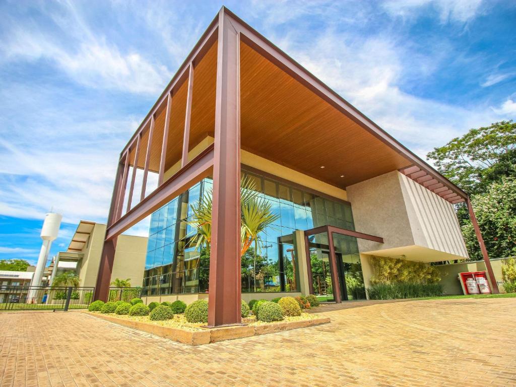 a large building with glass windows on a street at ibis Styles Bonito in Bonito