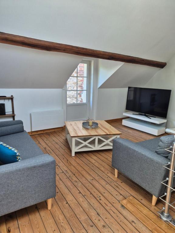 a living room with two couches and a flat screen tv at Gite independant Chateau-Renault Centre in Château-Renault