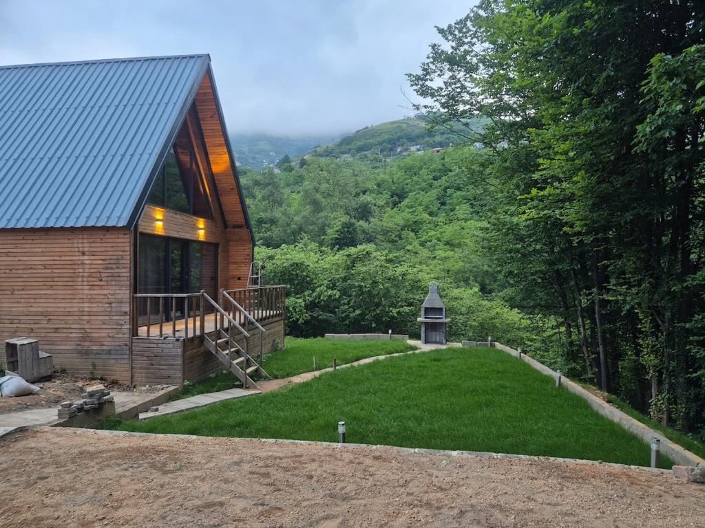 a house with a large yard next to a forest at Yonga Bungalov in Akcaabat