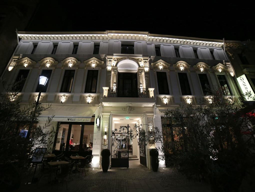 a white building with lights on it at night at The Mansion Boutique Hotel in Bucharest